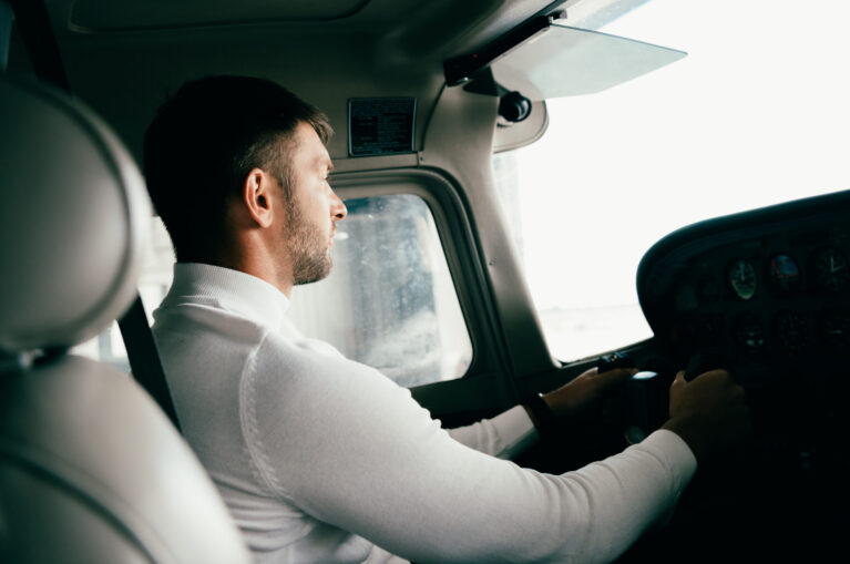 bearded young man in casual attire in plane